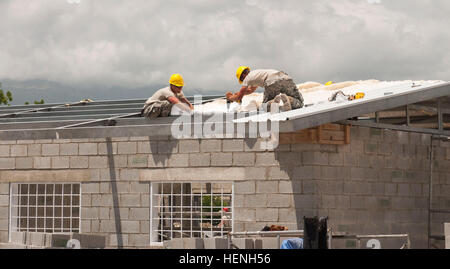 U.S. Army Cpl. Brandon A. Myers from Lancaster Pa., and U.S. Army Staff Sgt. Todd M. Schreffler from Selinagrove, Pa., both with the 358th Engineer Company out of New Cumberland, Pa., put in the installation in the roof of a clinic in Pescaderia, Barahona on May 24. The clinic is being built as part of the Beyond the Horizon 2014 mission to build schools and clinics for the local residents of Barahona, Dominican Republic. (U.S. Army photo by Sgt. Lindsey Schulte, 364th Press Camp Headquarters, Task Force Larimar) Beyond the Horizon progress 140524-A-GL519-001 Stock Photo