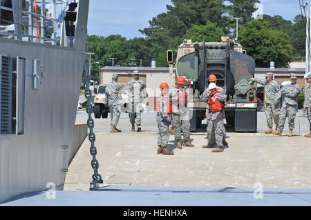 Soldiers from the 97th Transportation Company (Heavy Boat) consult before loading a M915 A5 fuel truck and trailer onto Landing Craft Utility 2006, the 'Bristoe Station' at the Joint Base Langley/Eustis seaport June 5. Soldiers from the 298th Transportation Company drove the vehicles from their headquarters in Clearfield, Penn. These vehicles are part of the 2014 Quartermaster Liquid Logistics Exercise, which spans the East Coast and incorporates Active Duty and Reserve components as well as Navy, Marine, and Coast Guard personnel.(Photo by Spc. C. Terrell Turner, 214th Mobile Public Affairs D Stock Photo