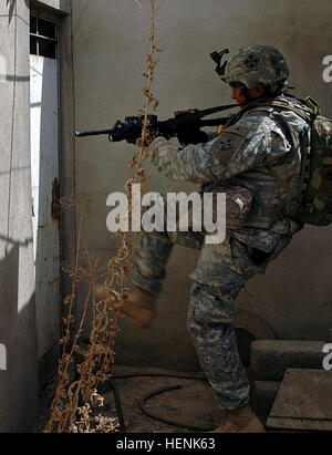 Spc. Mark Ramirez, an infantryman in 1st Platoon, Company D, 1st Battalion, 8th Infantry Regiment from Fort Carson, Colo., works to negotiate a locked door during a clearing operation in Mosul, Iraq, April 1. A car bomb factory, several bags of homemade explosives and bomb making materials were found and destroyed during the raid. Iraqi Army Division led raid on Mosul neighborhood finds car bomb factory 83282 Stock Photo