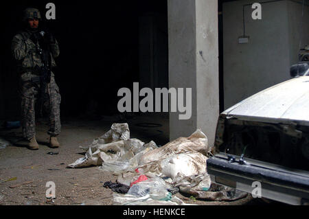 1st Lt. Donald Maloy, 1st Platoon leader, Company D, 1st Battalion, 8th Infantry Regiment from Fort Carson, Colo., photographs several bags of homemade explosives found in a mechanics shop turned car bomb factory in Mosul, Iraq, April 1. Other bomb making materials as well as ammunition were found on the scene and destroyed. Iraqi Army Division led raid on Mosul neighborhood finds car bomb factory 83284 Stock Photo