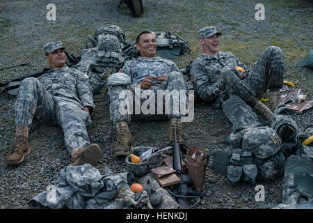 Spc. Rahmad Gholston, left, an air defense artillery specialist representing the 416th Theater Engineer Command, Staff Sgt. Francisco Vargas, center, a motor sergeant and squad leader representing the 807th Medical Deployment Support Command, and Spc. Keegan Carlson, right, representing the U.S. Army Civil Affairs and Psychological Command, relax after completing the land navigation course at the 2014 U.S. Army Reserve Best Warrior Competition, June 23. (U.S. Army photo by Sgt. 1st Class Mark Burrell) Night Land Navigation 2014 USARC BWC 140624-A-GX923-116 Stock Photo