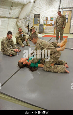 Sgt. Maria Acuna, a Modern Army Combatives Program level-three instructor with Task Force Warhawk, demonstrates how to obtain a dominant position to Soldiers in TF Warhawk July 17 at Shindand Airfield. Soldiers completed a 40-hour block of instruction to become MACP level-one certified. Warhawks dig talons into combatives 140717-A-XP915-003 Stock Photo