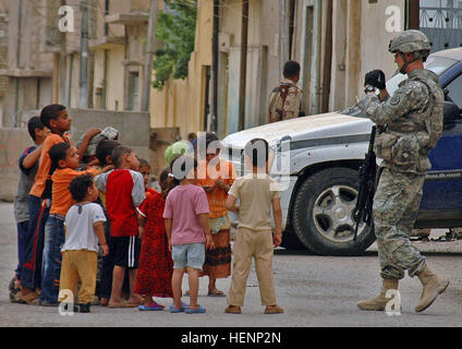 Chaplain's assistant Spc. Steven Kennedy takes a photo of Iraqi children outside an Iraqi Police station in Mosul, Iraq, on April 16. Kennedy is in Headquarters and Headquarters Troop, 3rd Squadron, 3rd Armored Cavalry Regiment from Fort Hood, Texas. Killer Troop shows softer side to Iraqi children, Mosul 84776 Stock Photo