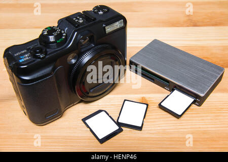 usb card reader with 3 cards and camera on wooden table ready to use Stock Photo