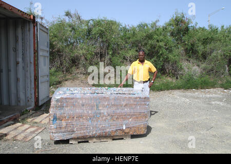 Leon McPherson, the base's refuse supervisor, stands next to a compacted block of plastic ready to be shipped back to be recycled in the states. The plastic block weighs around 734 pounds and was created from 20 tri-wall boxes full of plastic. GTMO recycles 140815-A-ZI015-007 Stock Photo