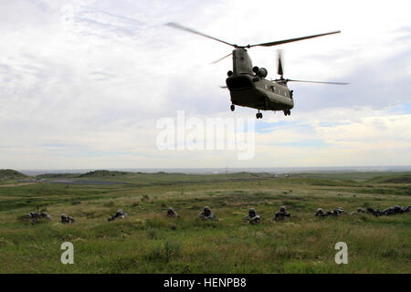 Soldiers of Headquarters and Headquarters Company, 1st Battalion, 38th Infantry Regiment, 1st Stryker Brigade Combat Team, 4th Infantry Division, maintain a defensive parameter as a CH-47 Chinook takes off during the first of a three-day Mortar Training and Evaluation Program, Aug. 19, 2014. “It was pretty exhilarating from the time the Chinook was hovering over us and landing to when it took off,” said Pvt. Dominic Carranza, indirect fire infantryman, Headquarters and Headquarters Company, 1st Battalion, 38th Infantry Regiment, 1st SBCT, 4th Infantry Division. 1-38 air assault mortar teams 14 Stock Photo