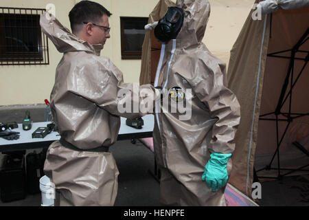 Staff Sgt. John Bennetts, survey team chief, 773rd Civil Support Team, 7th Civil Support Command and a native of Sioux Falls, S.D., native, left, removes a chemical protective suit from Sgt. Bajram Peci, leader decontamination station, 1st Platoon, Hazmat Company, Civil Protection Regiment, Kosovo Security Force and Mitrovica, Kosovo resident during a Defense Threat Reduction Agency sponsored-preparedness partnership program exercise on Panzer Kaserne Aug. 20, 2014 7th CSC Soldiers train Kosovo Security Force HAZMAT Company 140820-A-NP785-022 Stock Photo