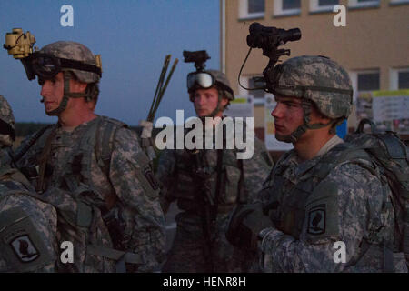 Spc. Nicholas Huddleston, a resident of North Ogden, Utah, (left) and Pvt. Andrew Phillips, (right) and a native of Alpena, Mich., both assigned to Company D, 2nd Battalion, 503rd Infantry Regiment, 173rd Airborne Brigade, listen to a brief near Drawsko Pomorskie, Poland before they board a UH-60 Black Hawk that will take them to the site of their night raid in support of Exercise Steadfast Javelin II Sept. 3, 2014. Company D conducted an air assault mission at night to destroy a radar site and to gather intelligence for other units to use throughout the exercise. Steadfast Javelin II is a NAT Stock Photo