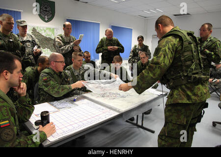 Lithuanian soldiers of 'Iron Wolf' Mechanized Infantry Brigade and a U.S. Soldier of 500th Engineer Company, 15th Engineer Battalion place an overlay on a map while working to coordinate missions during training exercise Saber Junction 2014 at the Joint Multinational Readiness Center in Hohenfels, Germany, Sept. 6, 2014. Saber Junction 2014 prepares U.S., NATO allies and European security partners to conduct unified land operations through the simultaneous combination of offensive, defensive, and stability operations appropriate to the mission and the environment. More information about Saber  Stock Photo