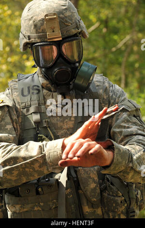 U.S. Army 1st Lt. Michael Theising, assigned to 15th Engineer Battalion, 21st Theater Sustainment Command, uses a skin decontamination kit during the CBRN (Chemical, Biological, Radiological and Nuclear) lane at the 2014 U.S. Army Europe Best Warrior Competition, Sept. 16 at Grafenwoehr, Germany. Unique to USAREUR, the Best Junior Officer Competition is designed to help young leaders keep their minds and skills sharp by pushing them mentally and physically in a challenge that promotes the knowledge, aptitude, leadership traits and esprit de corps that are fundamental for up-and-coming leaders. Stock Photo