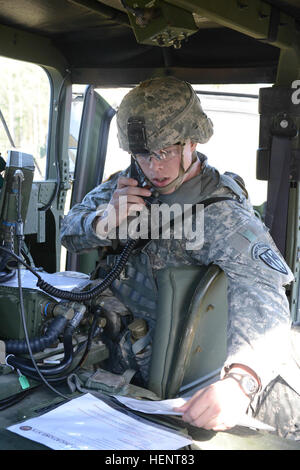 U.S. Army Staff Sgt. Jordan Stipp, assigned to 709th Military Police Battalion, 21st Theater Sustainment Command , checks his radio for the Tactical Communications lane during the U.S. Army European Best Warrior Competition event  in Grafenwoehr, Germany, Sept. 17, 2014.  The competition is a weeklong event that pushes Soldiers to the limits of their physical stamina, bearing, knowledge, adaptability and technical and tactical skills. The best warriors are ready and resilient Soldiers who live the Army values and lead from the front.  (U.S. Army photo by Spc. Franklin Moore/ Photo Released) 20 Stock Photo