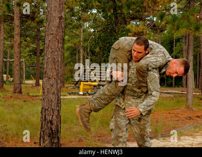 A medic assigned to the 82nd Airborne Division buddy carries another medic while navigating the obstacle course at the Division’s Pre-Ranger Course Oct. 7, on Fort Bragg, N.C. The obstacle course was part of the All American Best Medic Competition, which evaluates the medics’ tactical and technical proficiency in a variety of scenarios. The winning team will go on to compete in the Army-wide competition next month at Fort Sam Houston, Texas. (Sgt. 1st Class Joseph Armas/82nd Airborne Division) All American Best Medic Competition a test of mental and physical fortitude 141007-A-PX133-015 Stock Photo