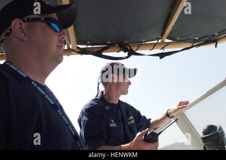 GUANTANAMO BAY, Cuba - Coast Guard Lt. Chris Keene, deck watch officer, examines the area while Coast Guard Petty Officer 1st Class Scott Blackketter, conning officer, pilots U.S. Guard Cutter Ocracoke as it pulls out from Guantanamo Bay, May 12, 2008. The Ocracoke docked only for a few days in the bay before continuing on to other missions. JTF Guantanamo conducts safe and humane care and custody of detained enemy combatants. The JTF conducts interrogation operations to collect strategic intelligence in support of the Global War on Terror and supports law enforcement and war crimes investigat Stock Photo