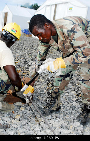 Armed Forces of Liberia engineers cut pieces of steel rebar during construction of the Ebola Treatment Unit in Tubmanburg, Liberia, Oct. 24, 2014. Joint Forces Command - United Assistance is working closely with the AFL to construct ETUs throughout Liberia in an effort to stop the Ebola outbreak. (Official U.S. Army Photo by Sgt. 1st Class Will Patterson/Released) UNMEER delegation visits US Ebola response operations in Liberia 141024-A-ZZ999-004 Stock Photo