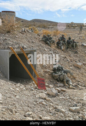 U.S. Soldiers of the 110th Military Police Company, 759th MP Battalion, and 748th Explosive Ordnance Disposal Company, attached to the 3rd Armored Brigade Combat Team, 4th Infantry Division, clear a cave complex held by role player insurgents as part of Decisive Action Rotation 15-02at Fort Irwin, Calif., Nov. 9, 2014. DA Rotations allow units to fully exercise their mission-essential task list that supports the Army’s core competencies: Wide area security and combined arms maneuver. (U.S. Army photo by Spc. Ashley Marble/Released) Fort Irwin, National Training Center Decisive Action Rotation  Stock Photo