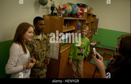U.S. Army Soldiers participate in community outreach with Latvian forces in Gulbene, Latvia, engaging with students through photos, discussions, and educational activities. Stock Photo