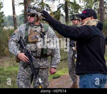 A team leader with 3rd Ordnance Battalion Explosive Ordnance Disposal, 71st Ordnance Group EOD, Joint Base Lewis-McChord, Wash., interacts with a role-player during a certification exercise Nov. 18, on JBLM. The exercise was designed to mimic real-world scenarios and test EOD personnel on their capabilities. (U.S. Army photo by Sgt. Cody Quinn, 28th Public Affairs Detachment/Released) JBLM EOD trains for real-world scenarios 141118-A-BX700-106 Stock Photo