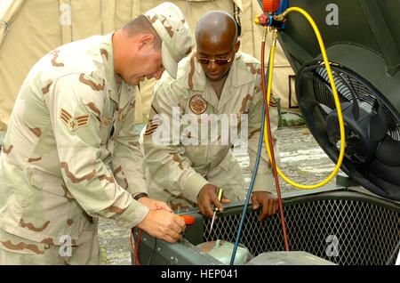 GUANTANAMO BAY, Cuba- Senior Airman Mark Huffer, left, and Master Sgt. Marcus Hill of the 474th Expeditionary Civil Engineering Squadron conduct a routine preventative maintenance inspection on a field deployable environmental control unit at Camp Justice on U.S. Naval Station Guantanamo Bay. This heating/cooling system is provided for every tent in Camp Justice. The 2 hour long inspection includes checking refrigerant pressure readings, voltage and amperage readings, examining all filters and tightening all bolts and screws as well as other maintenance actions. JTF Guantanamo conducts safe an Stock Photo