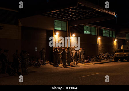 Paratroopers line the street before the sun rises, waiting to donate their toys in hopes of receiving a winning lottery ticket for the opportunity to earn foreign jump wings at the 17th Annual Randy Oler Memorial Operation Toy Drop. The airborne operation is hosted by the U.S. Army Civil Affairs & Psychological Operations Command (Airborne), a U.S. Army Reserve operational command, Dec. 5, 2014 at Pope Field, N.C. Operation Toy Drop is the world’s largest combined airborne operation with seven allied partner nation paratroopers participating and allows Soldiers the opportunity to help children Stock Photo