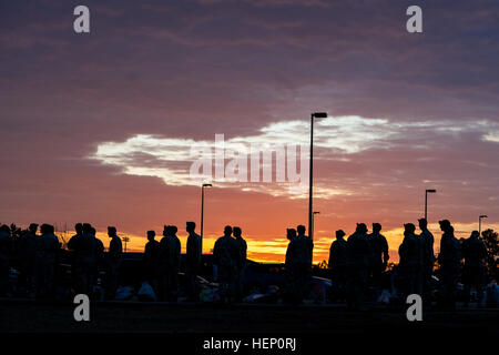 Paratroopers line the street as the sun rises, waiting to donate their toys in hopes of receiving a winning lottery ticket for the opportunity to earn foreign jump wings at the 17th Annual Randy Oler Memorial Operation Toy Drop. The airborne operation is hosted by the U.S. Army Civil Affairs & Psychological Operations Command (Airborne), a U.S. Army Reserve operational command, Dec. 5, 2014 at Pope Field, N.C. Operation Toy Drop is the world’s largest combined airborne operation with seven allied partner nation paratroopers participating and allows Soldiers the opportunity to help children in  Stock Photo