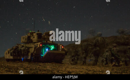 U.S. Soldiers, assigned to Bravo Company, 1st Squadron, 9th Cavalry Regiment, 2nd Brigade Combat Team, 1st Cavalry Division, dismount an M1 Abrams Tank outside an enemy compound during Decisive Action Rotation 15-05 at the National Training Center, Fort Irwin, Calif., Feb. 25, 2015. The rotation ensures brigades remain versatile, responsive and consistently available for the current fight and unforeseen future contingencies. (U.S. Army photo by Sgt. Richard W. Jones Jr./Released) Soldiers breach an enemy compound 150225-A-QU939-137 Stock Photo