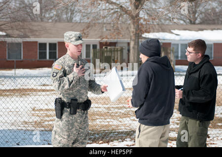 Spc. Brian Coates, a military police officer assigned to the 218th Military Police Company, 716th Military Police Battalion, supported by the 101st Sustainment Brigade, 101st Airborne Division, questions Spc. Trenton Taitague, a member of the Fort Campbell Special Reaction Team portraying a domestic abuse perpetrator, during a domestic violence training scenario Feb. 26 at Fort Campbell. Sgt. Ronald J. Wheat III, a military police investigator assigned to the 163rd Military Police Detachment, 716th MP Bn. and one of the lead trainers for the scenario observes Coates' performance. (U.S. Army ph Stock Photo