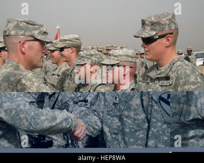 Lt. Col. Cameron Cantlon, commander of 6th “Saber” Squadron, 9th Cavalry Regiment, 2nd Advise and Assist Brigade, 1st Infantry Division, United States Division – Center and an Ettrick, Wis., native, congratulates Spc. Christian Cowan, a combat medic with A Troop, 6th Sqdn., 9th Cav. Regt. and a Van Buren, Ark., native, after he was awarded the Combat Medical Badge during a ceremony, April 29, at Camp Liberty, Iraq. The badge, created in 1945 by the War Department, is awarded to Army medics who performed medical duties while being engaged by the enemy. (U.S. Army photo by 2nd Lt. Daniel Elmblad Stock Photo