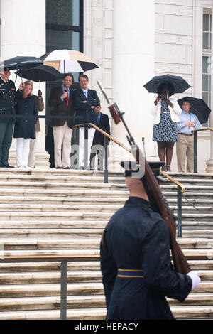 The Belgian Duke of Arenberg, third left, and Count Bernard de Grunne, fourth left, watch a Changing of the Guard Ritual at the Tomb of the Unknown Soldier with wounded warriors and others in Arlington National Cemetery, April 14, 2015, in Arlington, Va. The duke later laid a wreath at the tomb, with a note saying, “In remembrance of the American troops, among others, Colonel Albert Metts, who liberated my mother, Princess Sophie, and her family, the royal family of Bavaria, from the Nazi death camps Oranienburg-Flossenburg-Dachau in May 1945. Duke Leopold of Arenberg.'(Arlington National Ceme Stock Photo