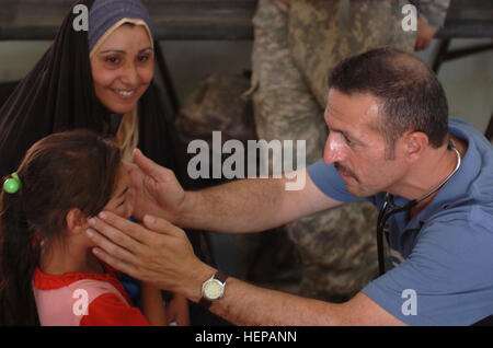 Dr. Yousif Yousif, an Iraqi physician, examines the swelling on a Iraqi childs face during a medical operation in Baghdad's Iraqi Family Village July 26. Soldiers with 1st Battalion, 320th Field Artillery Regiment, 2nd Brigade Combat Team, 101st Airborne Division (Air Assault), Multi-National Division - Baghdad, held the operation to help heal many of the different ailments plaguing the area.  (U.S. Army photo by Sgt. James P. Hunter, 2nd BCT PAO, 101st Abn. Div., MND-B) Top Guns, Iraqi doctors provide medical care to Iraqis in Baghdad 106578 Stock Photo