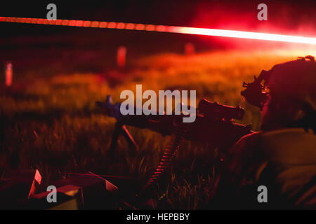 A Chile special forces soldier assists a U.S. SF soldier engage practice targets April 22, 2015, during night fire training in Camp Shelby, Miss., as part of a bilateral training exchange organized by members of Special Operations Command South. The training exchange promotes cooperation among peer nations as both countries share common concerns in the region regarding threats such as transnational organized crime and terrorism. (U.S. Army photo by Staff Sgt. Osvaldo Equite/Released) US, Chile SF night fire 150422-A-KD443-201 Stock Photo