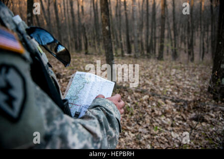Spc. James Ward, competitor from Lakewood, Wash., with the 494th Brigade Support Battalion, checks his map during a land navigation course through the hilly woods of Fort McCoy, Wis., April 27 as part of the 2015 Combined Theater Engineer Commands' (TEC) Best Warrior Competition, which lasted from April 25 to 29. The competition was organized and hosted by the 412th and 416th TECs Winners will move forward to compete at the U.S. Army Reserve Command level. (U.S. Army photo by Sgt. 1st Class Michel Sauret) 2015 Combined TEC Best Warrior Competition 150427-A-TI382-367 Stock Photo