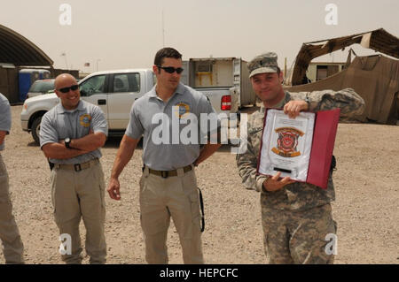 First Lt. Earl Yevak, a native of Hampton, Va., and a soldier with the 162nd Area Medical Support Company, Texas National Guard, displays his Outstanding Fire Warden award outside the Medical Troop Facility on Contingency Operating Base Basra. Yevak was recognized by Sallyport Global Holdings fire department on COB Basra for his service as a fire warden to one of the camps on base. Going above and beyond his duties, Texas guardsman receives fire warden award 110409-A-RT268-125 Stock Photo