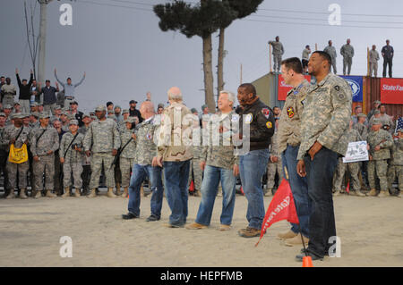 Fox Sports NFL Sunday commentators (from left to right) Jay Glazer, Terry Bradshaw, Jimmy Johnson, Curt Menefee, Howie Long, and Michael Strahan, talk to the crowd of service members before the taping of the NFL pre-game show at Bagram Airfield, Afghanistan, Nov. 7. Approximately 50 personnel from Fox Sports came to Afghanistan to film and produce the pre-game show as a way of saying thank you to the service men and women who are currently deployed. During their trip the NFL personalities visited and signed autographs for the troops and even tried several tasks that service members perform dai Stock Photo