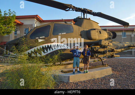 Jheiko Watson (left) and Connor Montague (right), Cub Scouts from Pack 8 in El Paso, Texas, salute the troops in front of a AH-64 “Apache” helicopter at 1st Armored Division Combat Aviation Brigade’s Headquarters. By helping raise the American flag, Connor was completing his last task of 12 to become a Wolf, the second level in the Cub Scouts. (U.S. Army photo by Sgt. Jose Ramirez, Combat Aviation Brigade Public Affairs, 1st Armored Division) Cub Scouts visit the CAB 150622-A-AG877-531 Stock Photo
