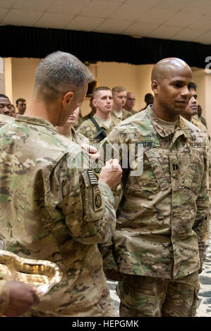 Capt. Orlando Martinez, right, company commander of Alpha Company, Headquarters and Headquarters Battalion, 82nd Airborne Division, receives the shoulder sleeve insignia-former wartime service from Maj. Gen. Richard Clarke, commanding general of the Combined Joint Forces Land Component Command – Iraq, during a patching ceremony in Baghdad, Iraq, July 4, 2015. More than 100 paratroopers were awarded the patch signifying their service in the CJFLCC-I’s coalition effort to degrade and destroy the Islamic State of Iraq and the Levant. (U.S. Army photo by Sgt. William Reinier/Released) CJFLCC-I par Stock Photo