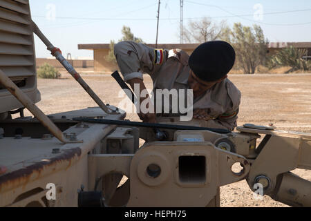 An Iraqi army engineer removes a mine roller during MaxxPro mine-resistant, ambush-protected vehicle training at Camp Taji, Iraq, July 11, 2015. Through advise and assist and build partner capacity missions, the Combined Joint Task Force – Operation Inherent Resolve’s multinational coalition has trained more than 10,000 Iraqi security force personnel to defeat the Islamic State of Iraq and the Levant. (U.S. Army photo by Spc. Paris Maxey/Released) Iraqi Army Soldiers train on mine sweeping and vehicle maintenance 150711-A-XM842-048 Stock Photo