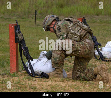 U.S. Army Pfc. Garrett Solomon, an infantryman assigned to Dog Company, 1st Battalion (Airborne), 503rd Infantry Regiment, 173rd Infantry Brigade Combat Team (Airborne) and native of Bellevue, Wash., adjusts sandbags on lane two prior to qualifying at the small arms firing range at the Lithuanian Grand Duke Gediminas Staff Battalion in Alytus, Lithuania, July 16, 2015. The Soldiers of Dog Company are in Europe as part of Atlantic Resolve, a demonstration of continued U.S. commitment to the collective security of NATO and to enduring peace and stability in the region. U.S. Army Europe is leadin Stock Photo