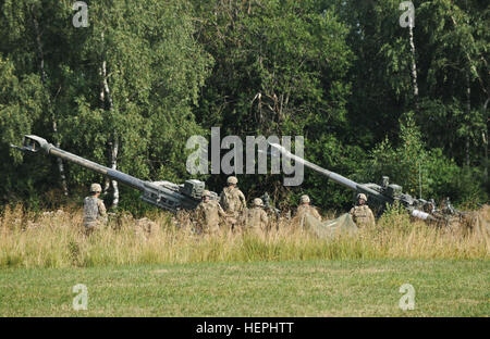 Troopers assigned to Alpha Battery, Field Artillery Squadron, 2nd Cavalry Regiment, adjust unit's M777A2 Howitzer weapons system into position during a firing demonstration, where they will fire an XM1156 Precision Guidance Kit fuse for the first time in the Regiment's history at Grafenwoehr Training Area located near Rose Barracks, Germany, July 24, 2015. The demonstration allowed the regiment to participate in new equipment training where the PGK fuse (which has global positioning system capabilities that aim to increase the accuracy of High Explosive and Rocket-Assisted Projectile artillery Stock Photo