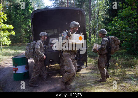 United States Army Soldiers assigned to Dog Company, 1st Battalion, 503rd Infantry Regiment, 173rd Airborne Brigade, muscle heavy ammunition boxes to and from a Lithuanian Land Forces transport vehicle, which they had to push to the next loading/unloading point during the final event of the LLF Best Squad Competition they took part in at the Great Lithuanian Hetman Jonusas Radvila Training Regiment, in Rukla, Lithuania, Aug. 27, 2015. Among other nations in the competition were Great Britain, Poland, Lithuania, Latvia, and Denmark. The competition was designed to test Soldier capabilities in a Stock Photo