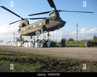 Sandbags weighing 4,000 pounds each are hooked to an Army National Guard CH-47 Chinook helicopter to repair a broken levee southeast of New Orleans, La., Sept.6, 2008. The levee was damaged by Hurricane Gustav. (Official U.S. Army photo by Sgt. Brian Cooper, 2nd Battalion, 135th Aviation Regiment, Colorado Army National Guard) Colorado Army National Guard Supports Hurricane Gustav Relief Efforts 116449 Stock Photo