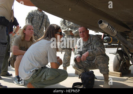 CAMP TAJI, Iraq – Sgt. 1st Class Daryl Yost, platoon sergeant, Company A, 1st Battalion, 4th Aviation Regiment, Combat Aviation Brigade, 4th Infantry Division, Multi-National Division – Baghdad from Cumberland, Md., shows Carlos Cavazo, guitarist for the classic rock 'n' roll band Big Noize an AH-64D Apache helicopter on Camp Taji Sept. 11. The band, comprised of members from Deep Purple, Ozzy Osbourne, AC/DC and Quiet Riot, visited the CAB and were at the camp north of Baghdad to entertain the troops with their musical selection of rock classics from the '70s and '80s.  (U.S. Army photo by Sg Stock Photo