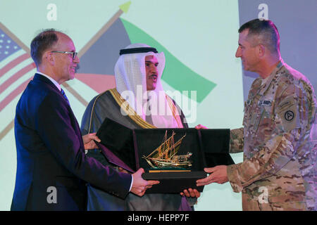 Ambassador Douglas Silliman, the U.S ambassador to Kuwait, and Sheikh Salman Sabah Al-Salem Al-Homoud Al-Sabah, Kuwait’s minister of information, present a gift to Maj. Gen. William Hickman, the U.S. Army Central, deputy commanding general-operations, after a special screening of “The Liberation of Kuwait, Honoring the Veterans of Desert Storm,” a documentary film commemorating the 25th anniversary of the liberation of Kuwait and the coalition and Kuwaiti veterans that served in the conflict, at Camp Arifjan, Kuwait, March 9, 2016. (U.S. Army photo by Sgt. Christopher Prows, USARCENT) US, Kuwa Stock Photo