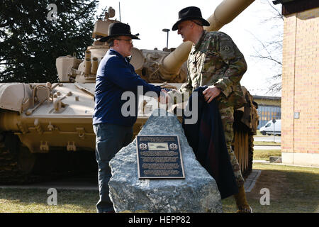 Retired Lt. Col. Timothy Gauthier (left,) former scout platoon leader with Eagle Troop and Lt. Col. Steven E. Gventer (right,) squadron commander assigned to 2nd Squadron, 2nd Cavalry Regiment, shake hands during the unveiling of a bronze plaque, placed in front of a T-72 Iraqi Tank, during the squadron's Battle of 73 Easting commemoration ceremony held at Rose Barracks, Germany, Mar. 11, 2016. The event was in celebration of the 25th anniversary of the unit's historic Operation Desert Storm victory and commemorated the history of the longest serving Cavalry Regiment in the United States Army. Stock Photo