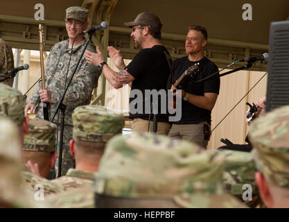Country singer Craig Morgan leads a round of applause for Sgt. Mark Bail, a Department of Public Works quality control noncommissioned officer with Area Support Group-Kuwait, during the USO’s 75th Anniversary Spring Tour at Camp Arifjan, Kuwait, March 15, 2016. Bail was called on stage by Morgan to sing an improvised song and received an autographed guitar afterward. (U.S. Army photo by Sgt. Youtoy Martin, U.S. Army Central Public Affairs) USO marks 75 years of bringing parts of home to the troops 160315-A-DP082-053 Stock Photo