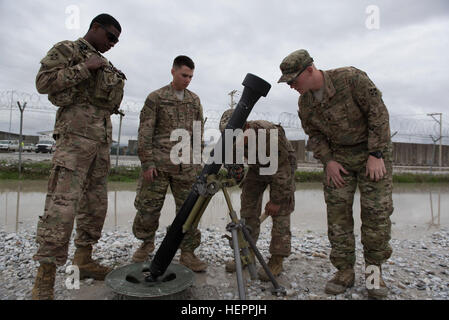 Sgt. Macven Solana, a mortarman noncommissioned officer and Long Beach, Cal. native, assesses the accuracy of Pvt. Mark McClung, a mortarman and Martinsburg, WV native, while performing gun drills in preparation for their 81mm mortar exam, Bagram Airfield, Afghanistan, April 2, 2016. All of the Soldiers are part of Headquarters, Headquarters Company, 1st Battalion, 12th Infantry Regiment, 'Warriors,' 4th Brigade Combat Team, 4th Infantry Division. Gun Drills 160402-A-QL991-013 Stock Photo