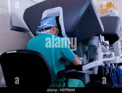 Dr. Samuel Cancel-Rivera, an OB-GYN physician looks through a 3D imaging system while operating on a patient using the latest state-of-the-art robotic surgical system at William Beaumont Army Medical Center, May 2. The surgeon-manipulated system allows for surgeons to operate with articulating instruments which bend and rotate far greater than the human wrist through an incision smaller than a centimeter.William Beaumont Army Medical Center performed the first robotic surgery in the Department of Defense using the surgical system. WBAMC first in DoD to use robot for surgery 160502-A-EK666-484 Stock Photo