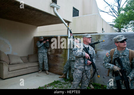 Soldiers of the 377th Detachment, 377th Company, and 377th Battalion out of Cincinnati, Ohio, tactically keep watch while a team clears a house during a Situational Training Exercise at Muscatatuck Urban Training Center, Ind., May 14th 2016. The training is part of the 377th Detachment, 377th Company, and 377th Battalion Battle Assembly to test the MPs knowledge and ability to react to realistic scenarios they may encounter in a deployed environment. (Photo by US Army Sgt. Marco Gutierrez.) Realistic Training for Military Police (Image 1 of 11) 160514-A-GT254-005 Stock Photo