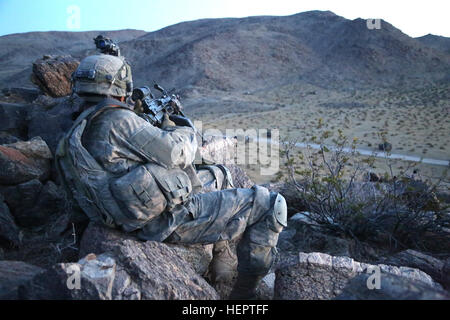 A U.S. Army Soldier assigned to 2nd Platoon, Alpha Company, 5th Battalion, 20th Infantry Regiment, 1st Brigade Combat Team, 2nd Infantry Division, provides security during Decisive Action Rotation 16-06 at the National Training Center in Fort Irwin, Calif., May 16, 2016. (U.S. Army photo by Sgt. Christopher Blanton, Operations Group, National Training Center) Watching from the high ground (27120316022) Stock Photo