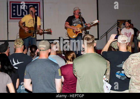 Jerrod Neimann (center), a country music artist, preforms for Soldiers of U.S. Army Central as part of the USO May Madness Tour on Camp Arifjan, Kuwait, May 18, 2016. The celebreties on the tour said they wanted to repay Servicemembers for their sacrifice and dedication to America. (U.S. Army photo by Sgt. David N. Beckstrom, 19th Public Affairs Detachment, U.S. Army Central) USO brings May Madness to Kuwait 160518-A-NU445-012 Stock Photo