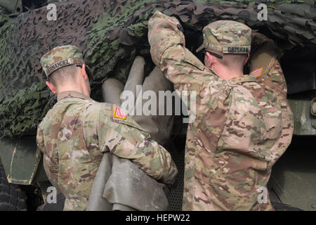 U.S. Soldiers attached to 4th Squadron, 2nd Cavalry Regiment during Dragoon Ride II, stow a floor mat onto their Stryker Armored Fighting Vehicle before a convoy from Powidz to Bydgoszcz, Poland, June 5, 2016. Dragoon Ride II, is the 2,200 kilometer convoy to Estonia in preparation for Exercise Saber Strike 2016, a U.S. Army Europe-led cooperative training exercise designed to improve joint interoperability to support multinational contingency operations. (U.S. Army photo by Staff Sgt. Ricardo HernandezArocho/Released) Dragoon Ride II Powidz to Bydgoszcz, Poland 160605-A-DM872-043 Stock Photo